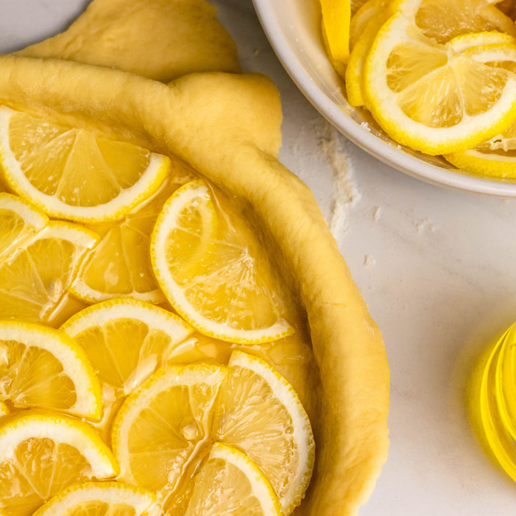 Zitronenkuchen mit frischen Zitronenscheiben wird zubereitet
